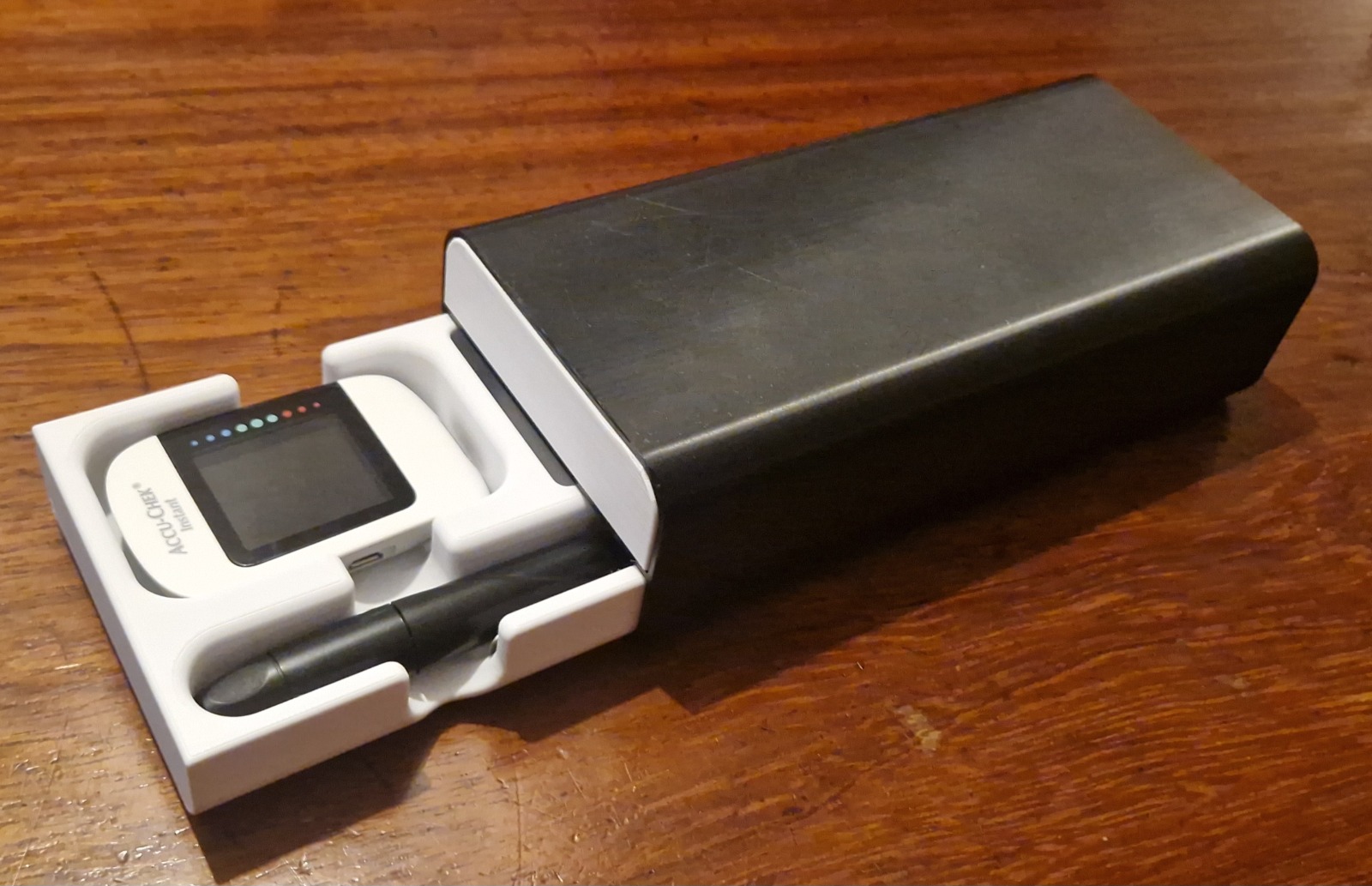 Arcacase Duo photographed with its organized glucose meter tray